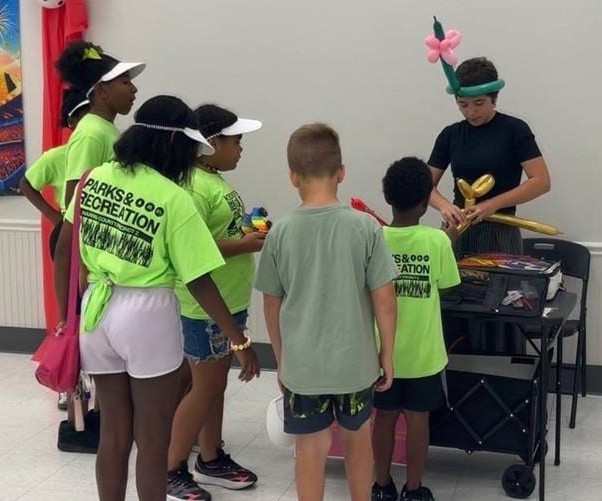 Balloon twisting for kids at a Texas summer camp event
