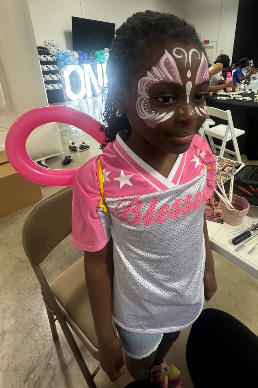 Butterfly face painting with a balloon at a Texas kids party