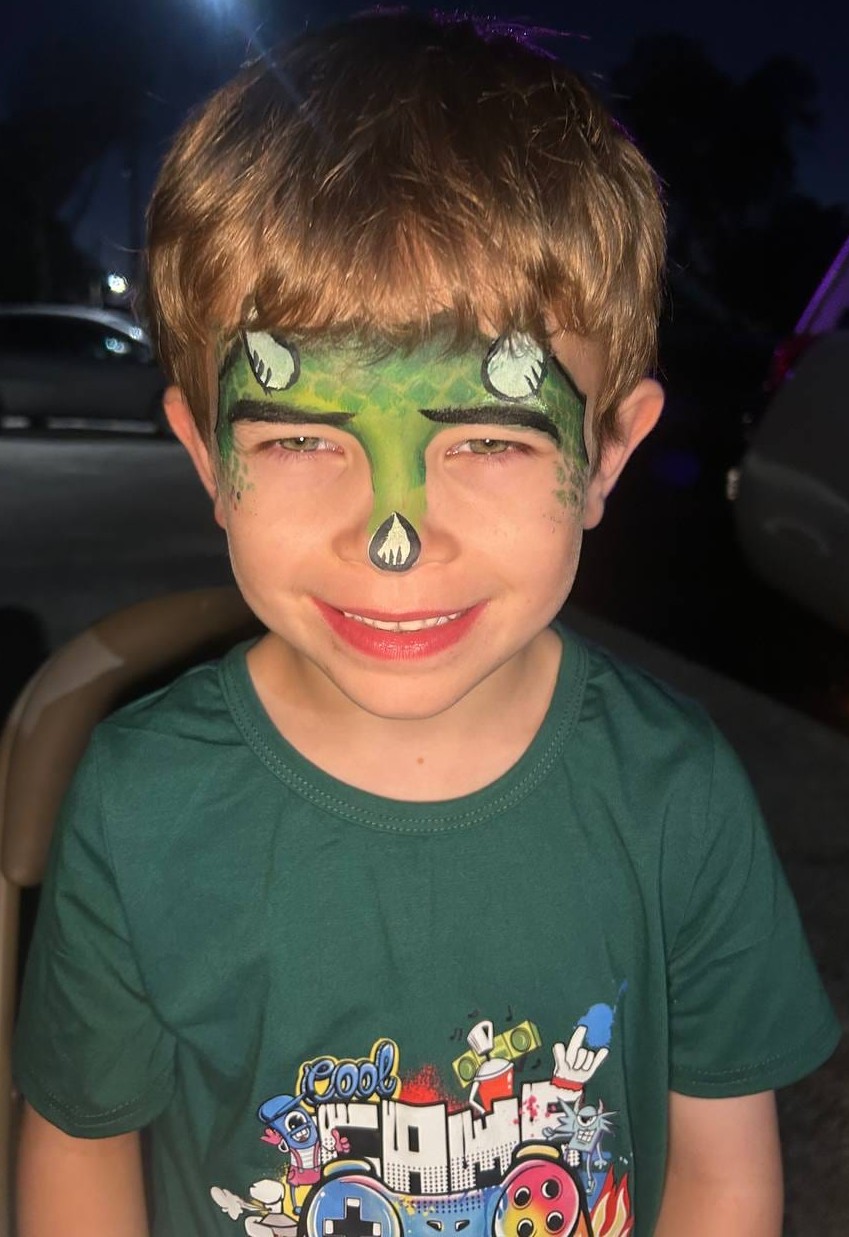 Dinosaur face painting on a child at a Texas party
