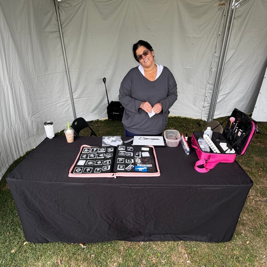 Glitter tattoo station with artist at a Texas event