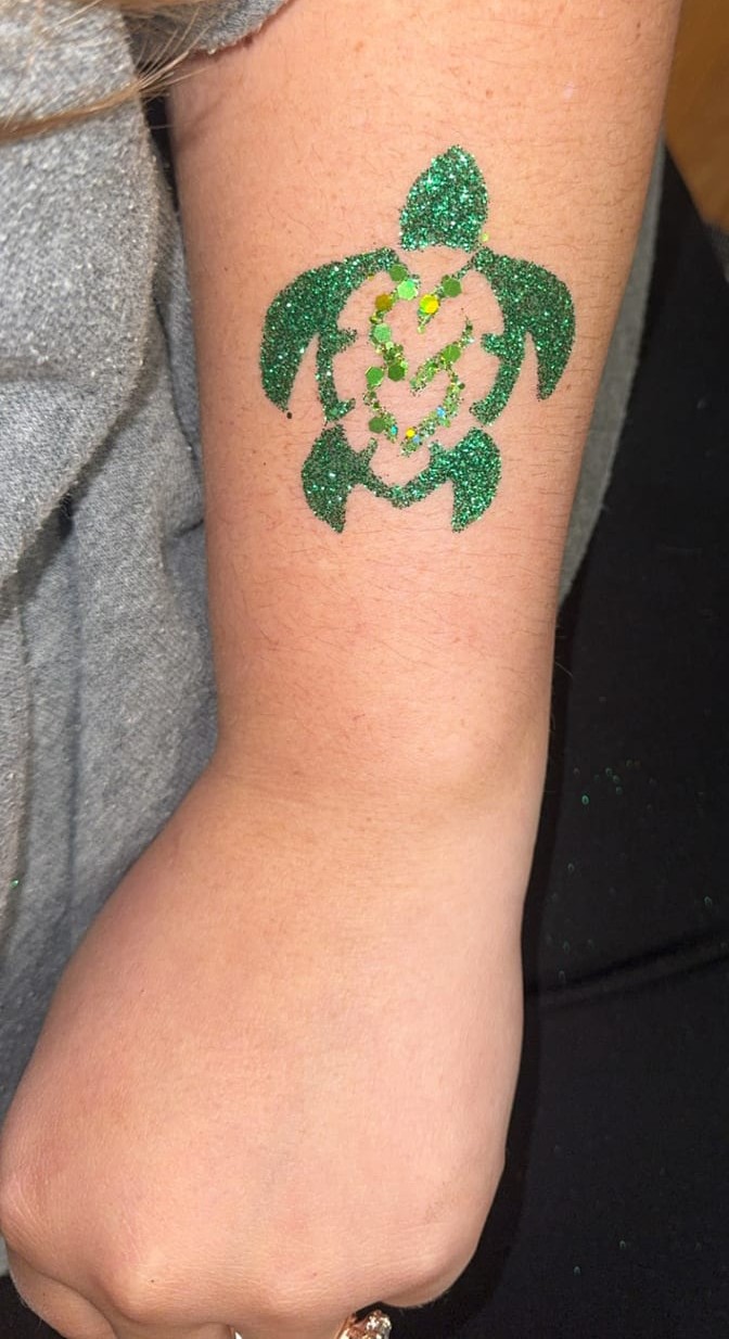 Sparkling turtle glitter tattoo at a Texas party
